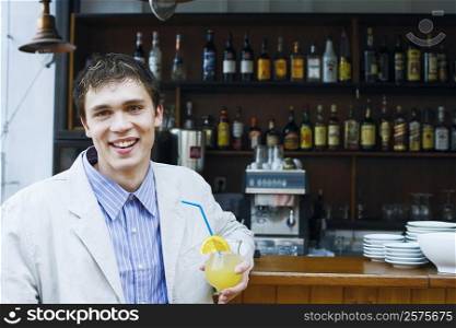 Portrait of a young man holding a drink