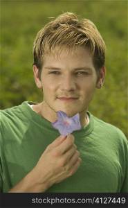 Portrait of a young man holding a flower