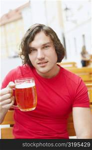 Portrait of a young man holding a glass of beer