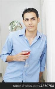 Portrait of a young man holding a glass of martini