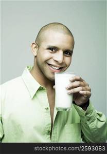 Portrait of a young man holding a glass of milk
