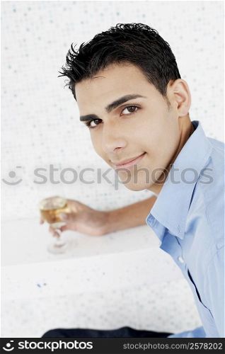 Portrait of a young man holding a glass of wine