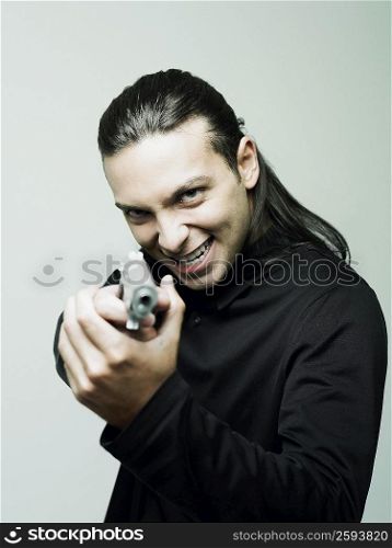 Portrait of a young man holding a handgun