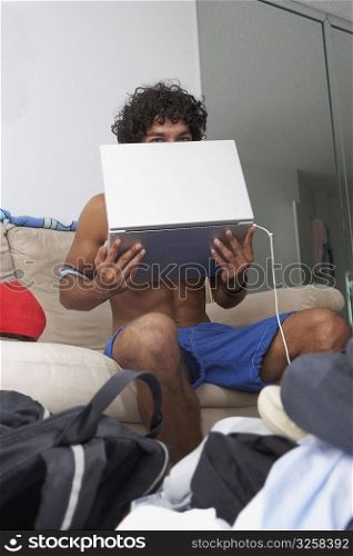 Portrait of a young man holding a laptop