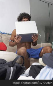 Portrait of a young man holding a laptop