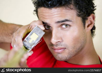 Portrait of a young man holding a measuring tape