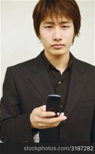 Portrait of a young man holding a mobile phone