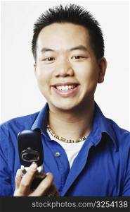 Portrait of a young man holding a mobile phone