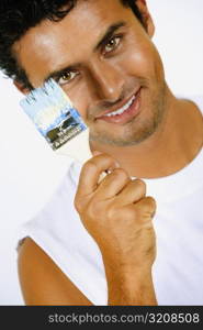 Portrait of a young man holding a paintbrush and smiling