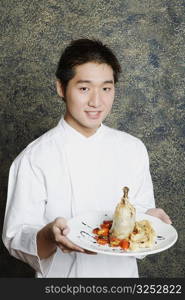 Portrait of a young man holding a plate of food