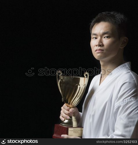Portrait of a young man holding a trophy