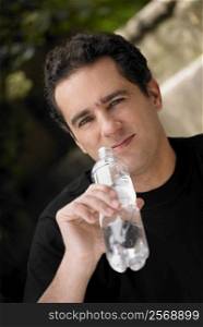 Portrait of a young man holding a water bottle