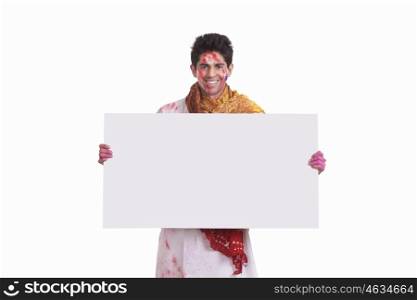 Portrait of a young man holding a white board