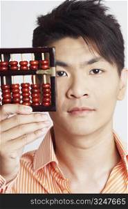 Portrait of a young man holding an abacus