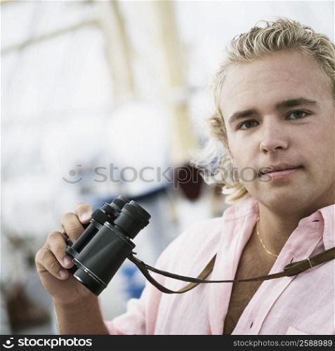 Portrait of a young man holding binoculars