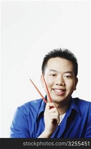 Portrait of a young man holding chopsticks