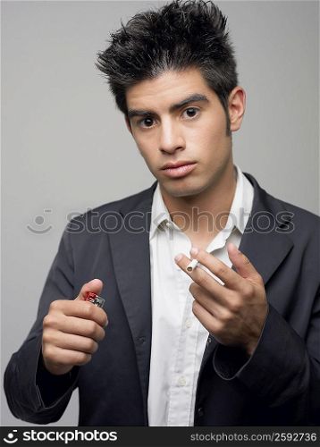 Portrait of a young man holding cigarette and a cigarette lighter
