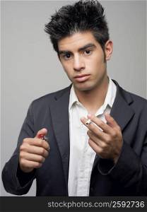 Portrait of a young man holding cigarette and a cigarette lighter