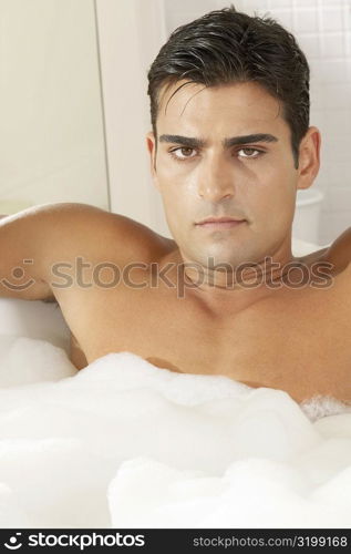 Portrait of a young man in a bubble bath