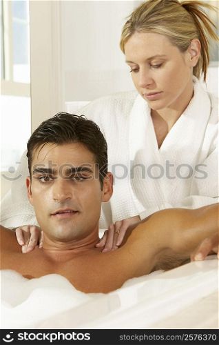 Portrait of a young man in a bubble bath receiving a massage