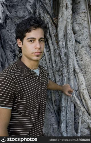 Portrait of a young man in front of a tree