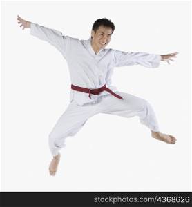 Portrait of a young man jumping and practicing martial arts