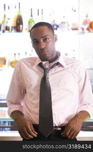 Portrait of a young man leaning against a bar counter