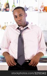 Portrait of a young man leaning against a bar counter