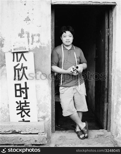 Portrait of a young man leaning against a door