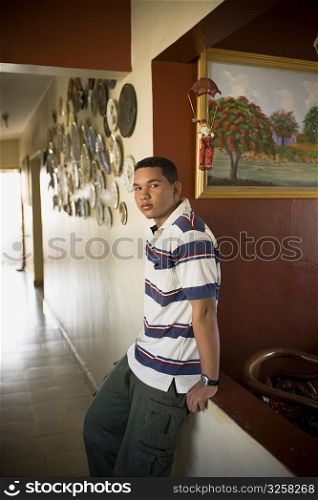 Portrait of a young man leaning against a wall and thinking
