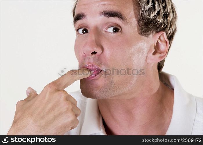 Portrait of a young man licking his finger