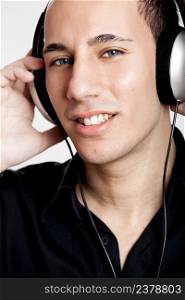 Portrait of a young man listening music with headphones