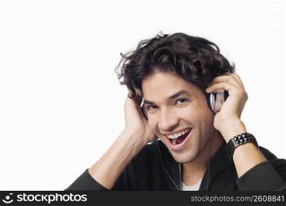 Portrait of a young man listening to music and laughing