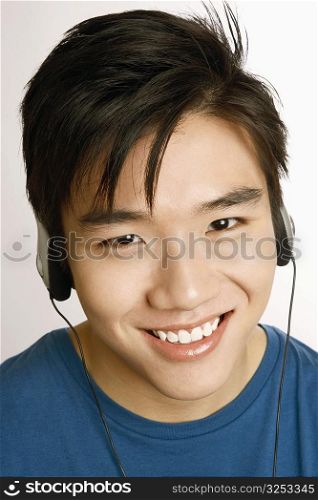 Portrait of a young man listening to music and smiling