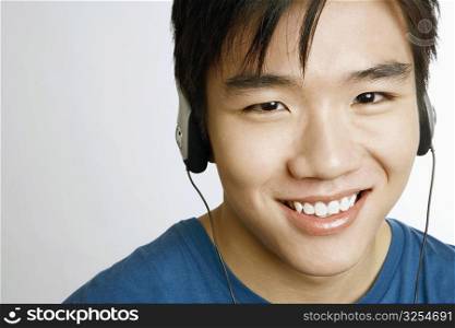 Portrait of a young man listening to music and smiling