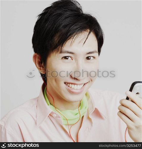 Portrait of a young man listening to music on a mobile phone