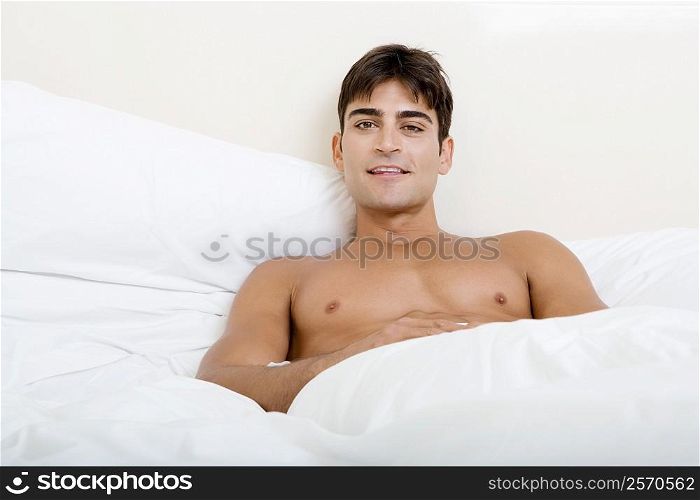 Portrait of a young man lying on the bed