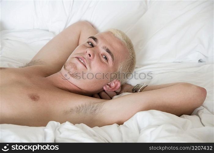 Portrait of a young man lying on the bed