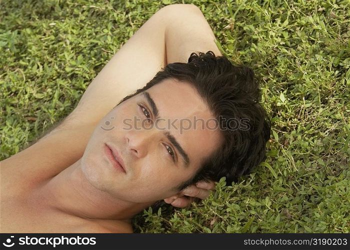 Portrait of a young man lying on the grass