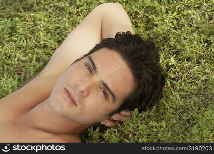 Portrait of a young man lying on the grass