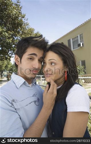Portrait of a young man making a face with a young woman looking at him