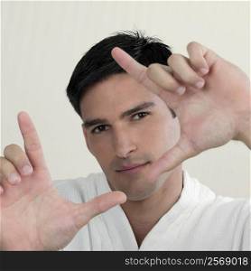 Portrait of a young man making a framing gesture