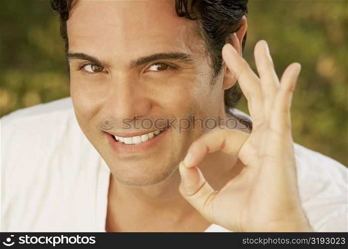 Portrait of a young man making an ok sign