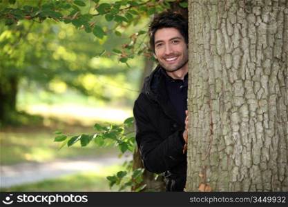 portrait of a young man next to a tree