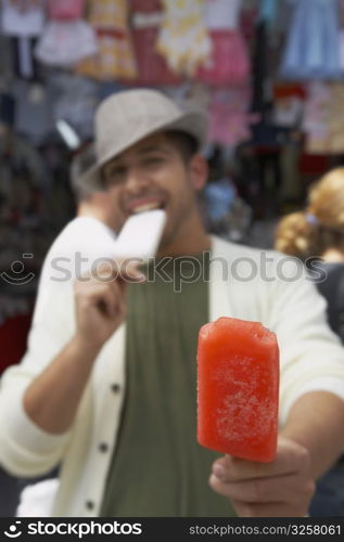 Portrait of a young man offering an ice cream
