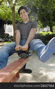 Portrait of a young man on a seesaw