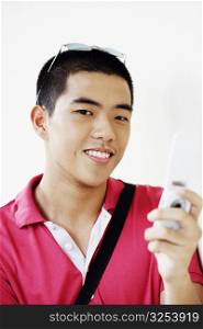 Portrait of a young man operating a mobile phone