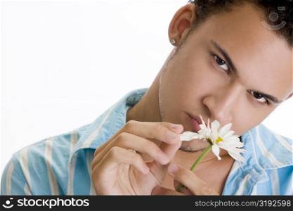 Portrait of a young man picking a flower