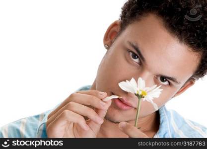 Portrait of a young man plucking petals of a flower