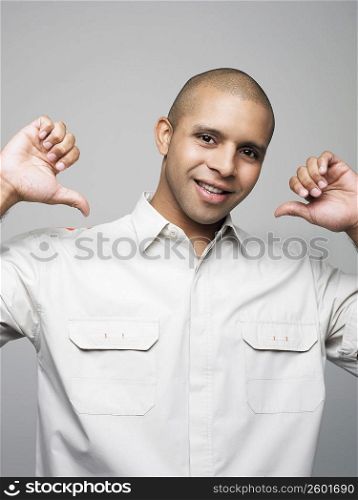 Portrait of a young man pointing at himself